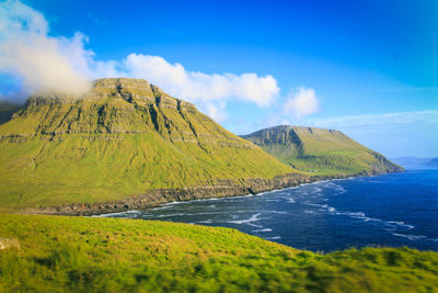 Scenic view of land and mountains against sky