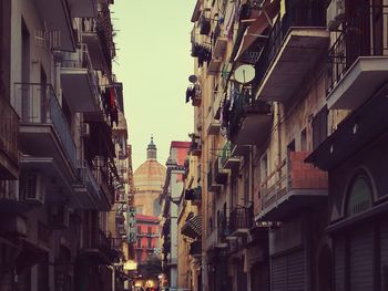 Low angle view of dome seen from alley amidst buildings in city