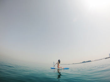 Young woman paddle boarding in dubai