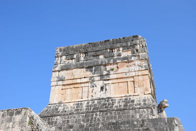 Low angle view of old building against clear blue sky