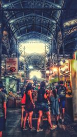 Rear view of people at illuminated market