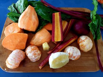 High angle view of fruits and leaves on cutting board