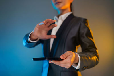 Midsection of man standing against blue background