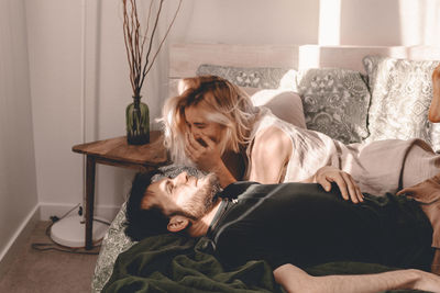 Couple lying on bed at home