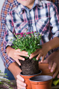 Midsection of boy potting plant