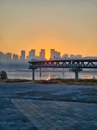 Bridge over river against sky during sunset