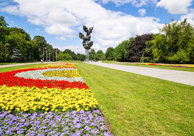 Scenic view of park against cloudy sky