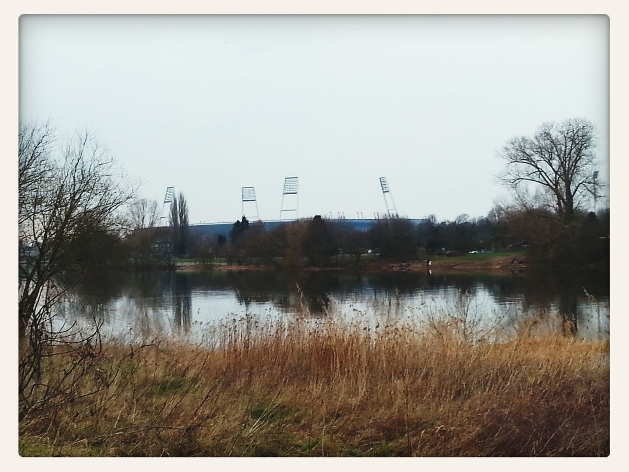 water, clear sky, lake, copy space, grass, tranquility, reflection, transfer print, tree, tranquil scene, river, auto post production filter, nature, sky, plant, built structure, scenics, lakeshore, architecture, day