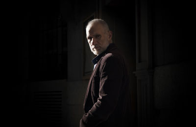 Adult man in suit on street in winter with sunlight and shadow