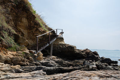 Scenic view of rocks by sea against sky