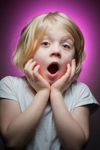 Close-up portrait of girl against pink background