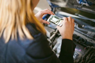 Close-up of woman photographing car engine