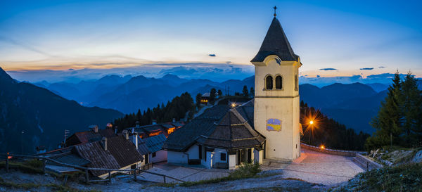 Church by building against sky during winter