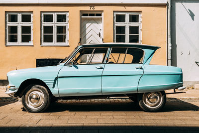 Vintage car parked against building in city