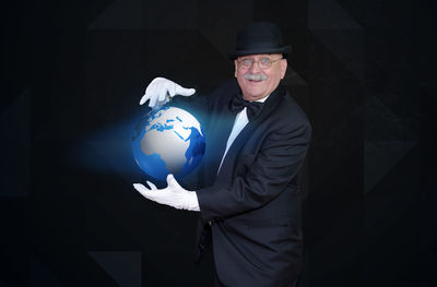 Portrait of senior man holding illuminated globe