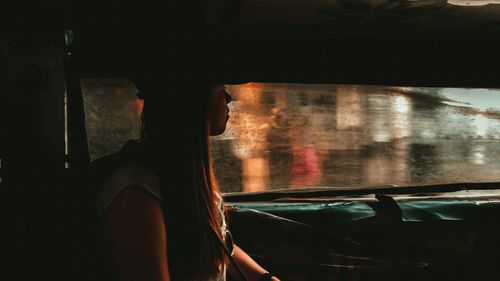 Side view of woman sitting in car