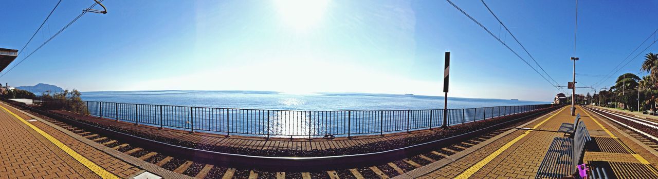 the way forward, sky, sea, sunlight, blue, water, clear sky, transportation, diminishing perspective, connection, panoramic, railing, vanishing point, tranquility, tranquil scene, sunny, horizon over water, cable, scenics, nature