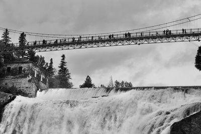 Low angle view of bridge over water against sky