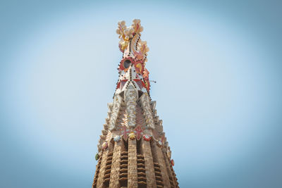 Low angle view of sculpture against building against clear sky