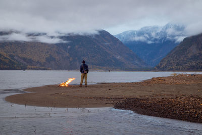 Man standing on beach against sky