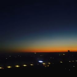 Illuminated cityscape against sky at night