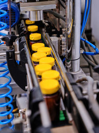 From above of modern pharmaceutical machine capping plastic bottles with liquid medicine on conveyor at factory