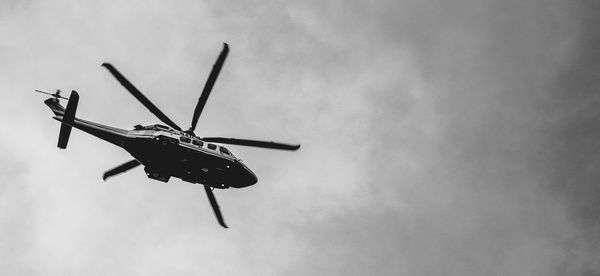 Low angle view of helicopter flying against sky