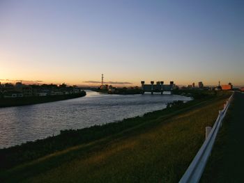 Scenic view of river against clear sky at sunset