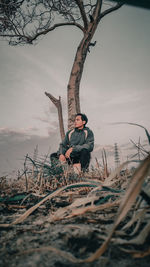 Man standing by tree against sky