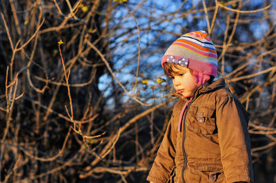 Close-up of person standing by bare tree during winter