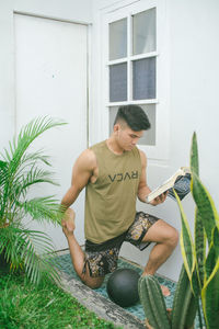 Young man sitting in yard