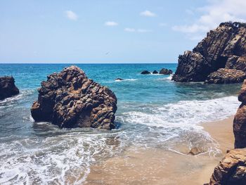Rock formation in sea against sky
