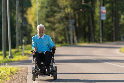 Rear view of man riding motorcycle on road