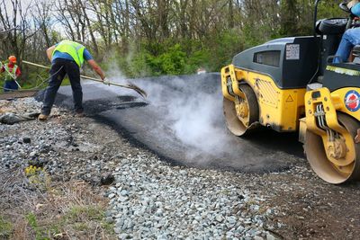 Road workers making asphalt on road