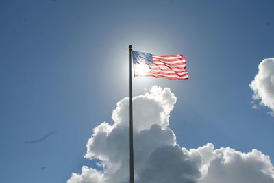 Low angle view of american flag against blue sky