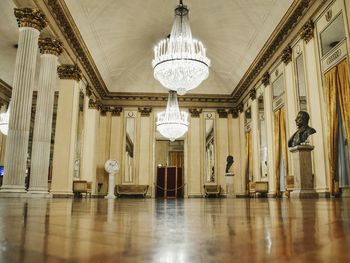 Low angle view of illuminated chandelier hanging in ceiling