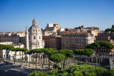 Buildings in city against clear blue sky