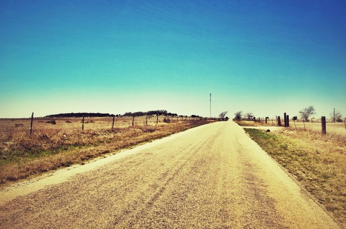 the way forward, clear sky, diminishing perspective, copy space, road, vanishing point, transportation, country road, landscape, blue, tranquil scene, field, tranquility, long, empty road, empty, dirt road, sky, nature, road marking