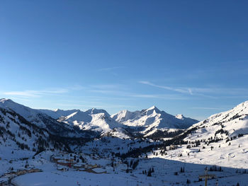 Scenic view of snowcapped mountains against clear blue sky