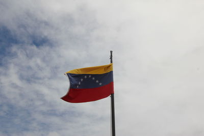 Low angle view of venezuelan flag waving against sky