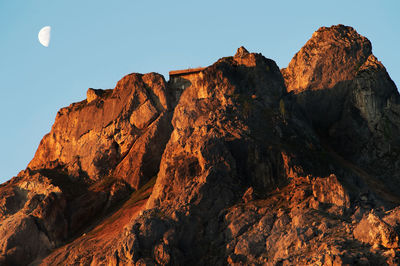 Low angle view of rocky mountains against clear sky