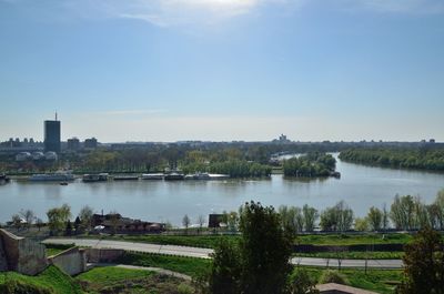 Scenic view of river by buildings against sky