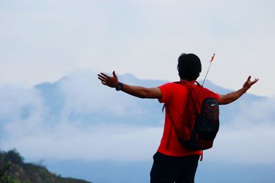 Rear view of man standing against sky