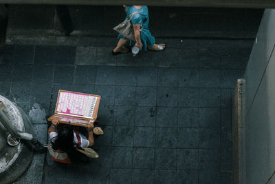 High angle view of woman sitting on street