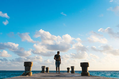 Full length of man standing at sea shore against sky