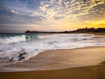 Scenic view of beach against sky during sunset