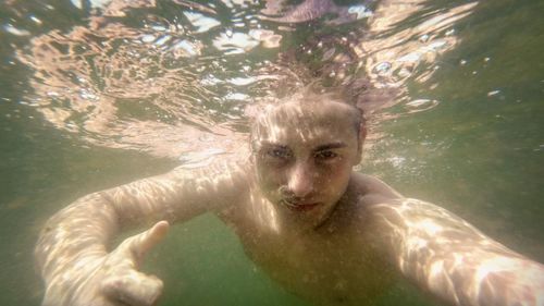 Portrait of shirtless boy swimming in sea