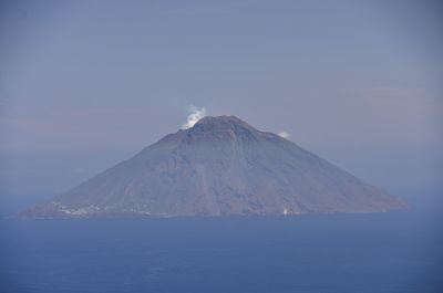 Scenic view of sea and volcano stromboli against sky
