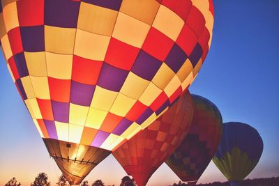 Low angle view of hot air balloons against sky during sunset