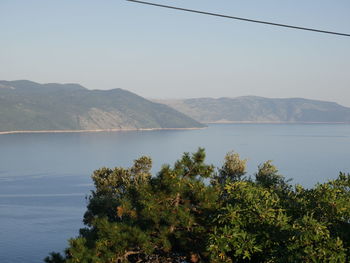 Scenic view of sea and mountains against clear sky